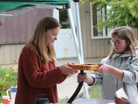 a woman handing a plate of food to another woman