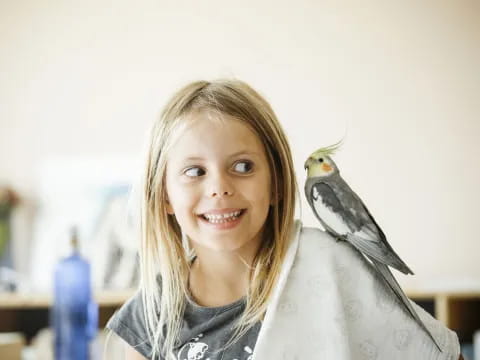 a girl with a bird on her shoulder