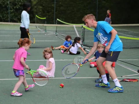 a person and kids playing tennis