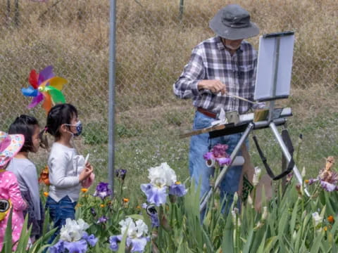 a person and a group of children looking at a person using a camera