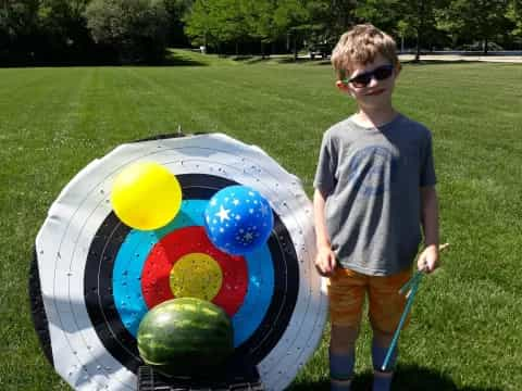 a boy holding a large blue and yellow ball with a blue ball in it