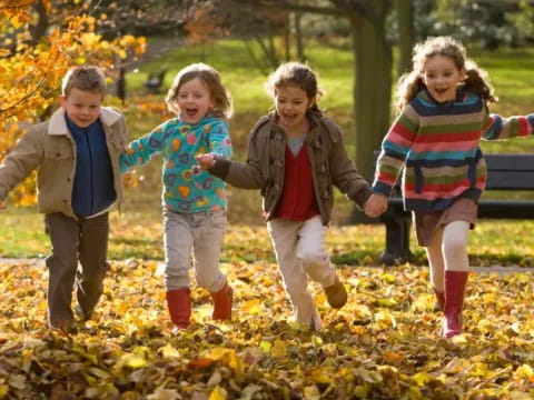 a group of children running in a park