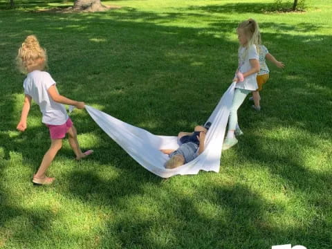 a group of children playing in a grassy area