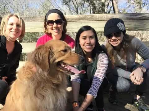 a group of people posing with a dog