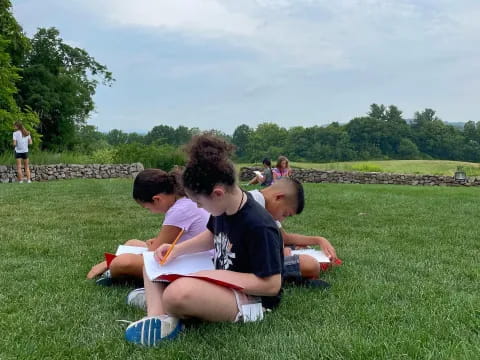 a group of people sitting on the grass