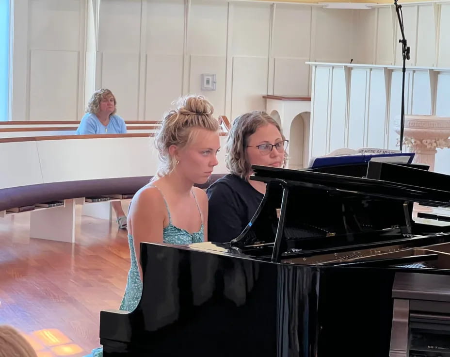 a couple of women playing piano