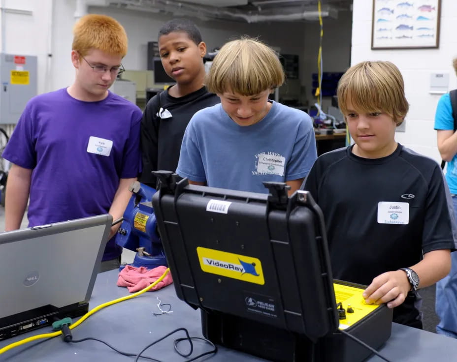 a group of young men looking at a computer