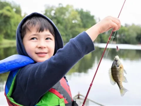 a boy holding a fish