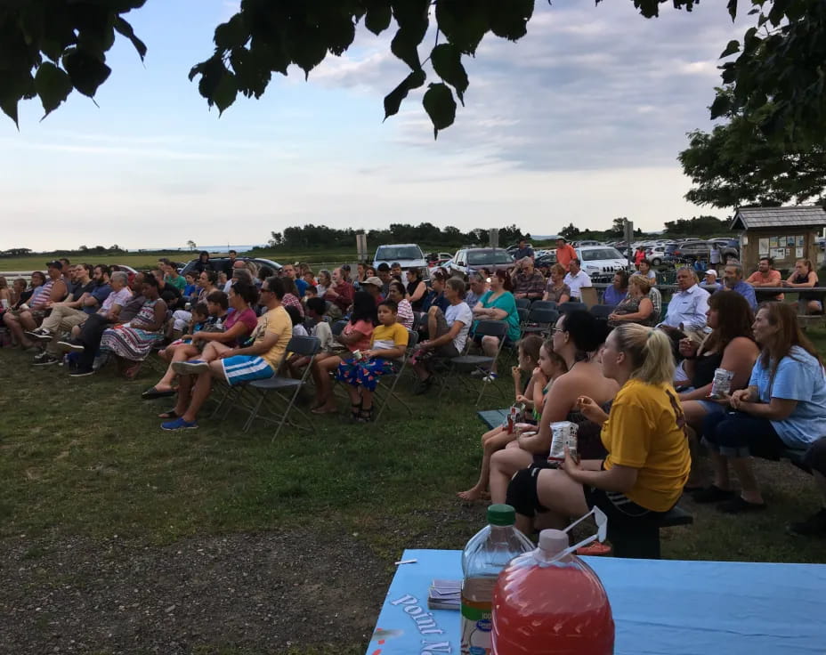 a large group of people sitting on chairs outside