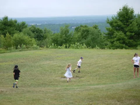 a group of people running on a grassy field