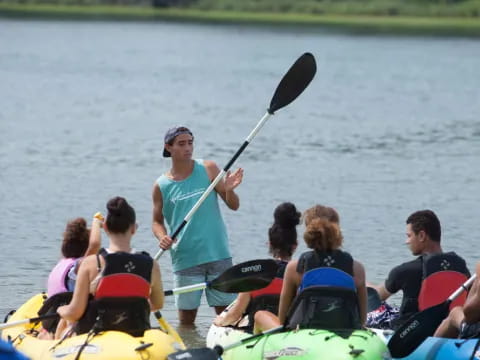 a person holding a paddle on a boat with a group of people in it