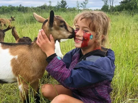 a girl with a deer licking her face