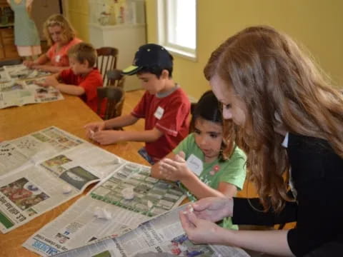 a person and children sitting at a table looking at a map