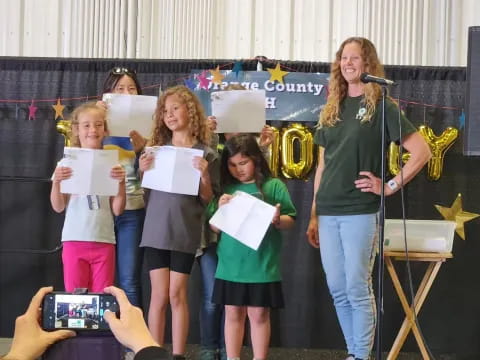 a group of girls holding papers