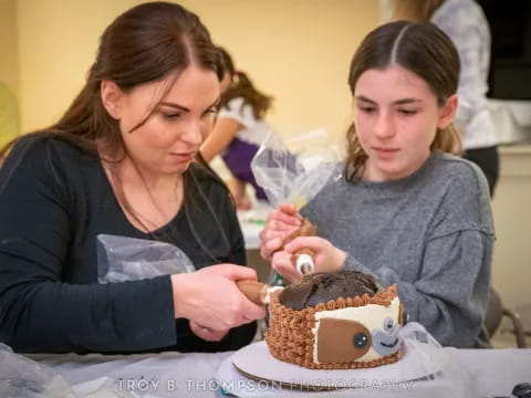 a couple of girls cutting a cake