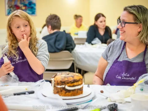 a woman and a girl eating cake