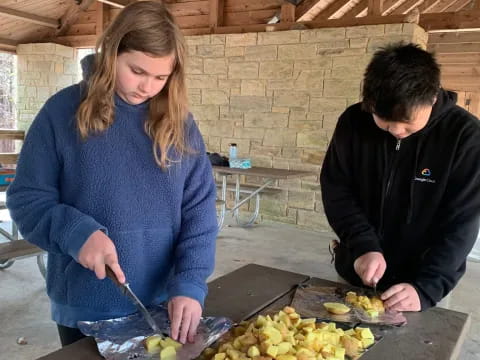 a man and a woman cutting vegetables