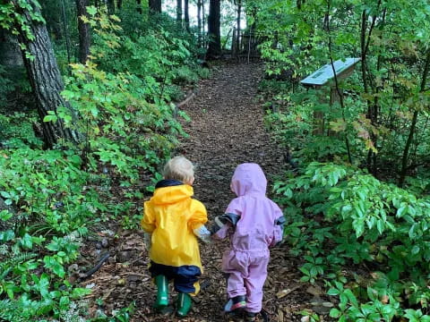 two children walking on a path in the woods