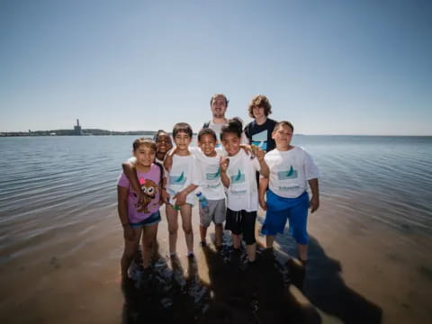 a group of people posing for a photo on a beach