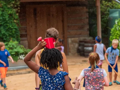 a group of children playing with a red cup