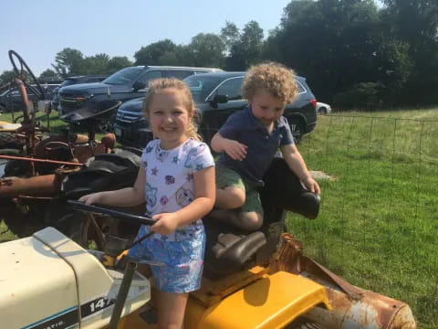 a couple of children on a tractor