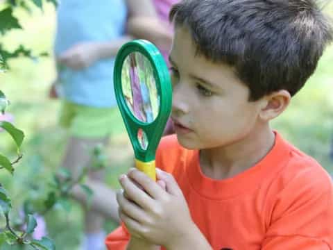 a young boy holding a green handled brush