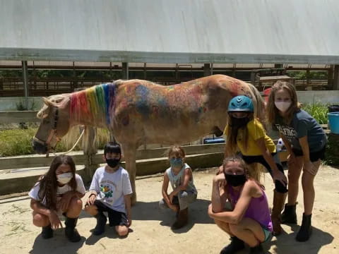 a group of people posing for a photo in front of a camel