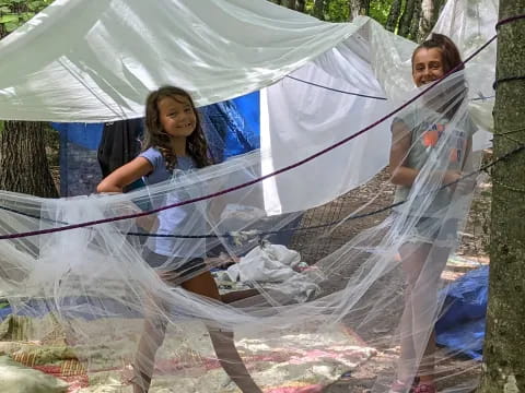 a couple of women in white dresses in a tent