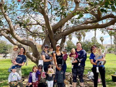 a group of people posing under a tree