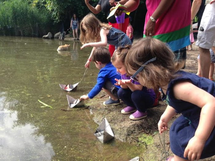 a group of people looking at a fish in a pond