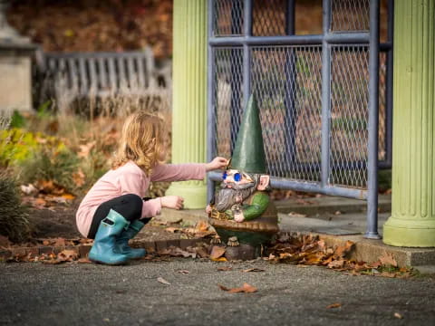 a girl playing with a toy frog