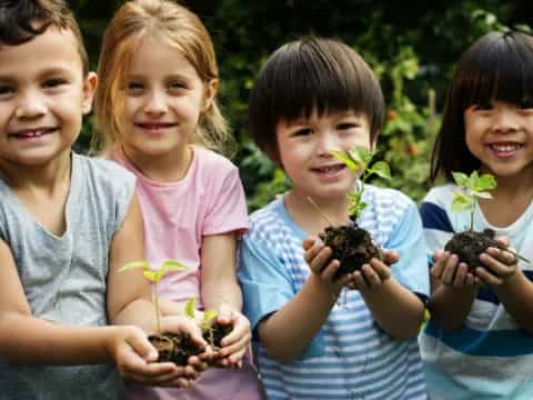 a group of children holding small plants