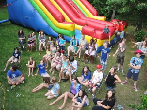 a group of people posing for a photo in front of a large colorful slide