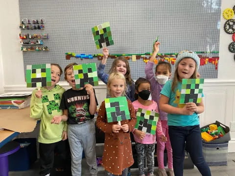 a group of children holding up green and yellow flags