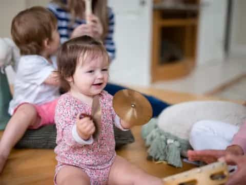 a baby girl holding a cookie