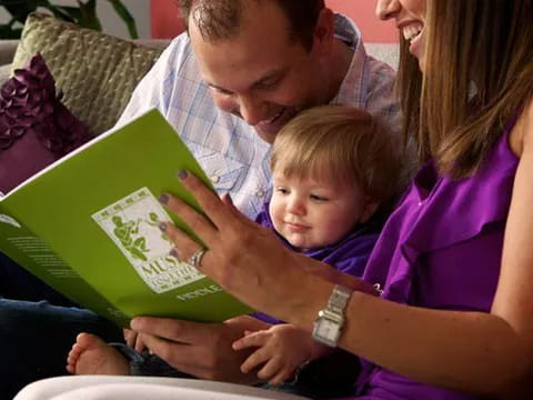 a person reading a book to a baby