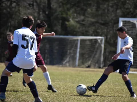 a group of boys compete over a football ball