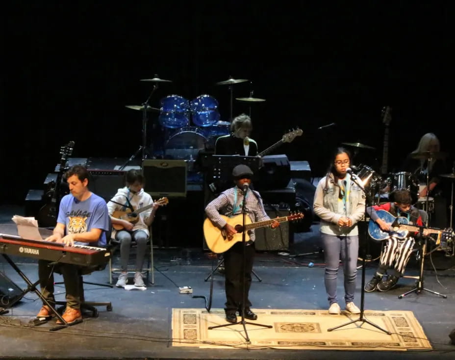 a group of people playing instruments on a stage