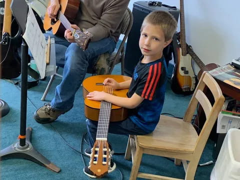 a person and a boy playing guitar