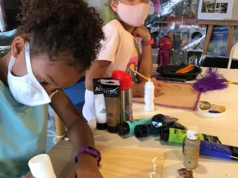 a person and a child playing with toys on a table
