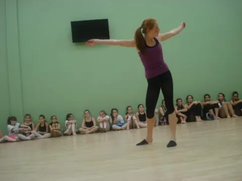 a woman dancing in front of a group of people