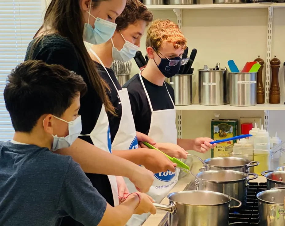 a group of people cooking in a kitchen