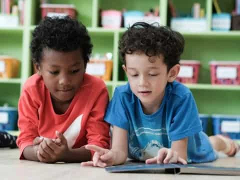 medium shot of kids looking at a book