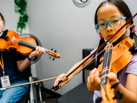 a couple of kids playing violin