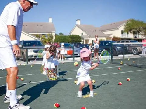 a man and a child playing tennis