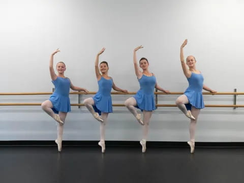 a group of women in blue dresses jumping in the air
