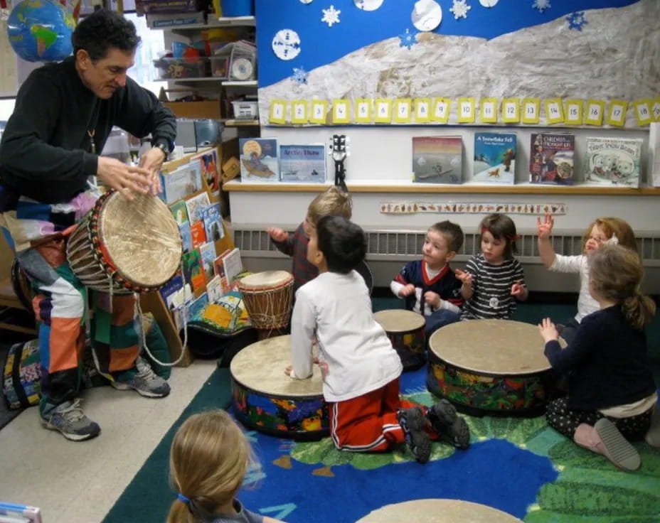 a person teaching children how to play drums