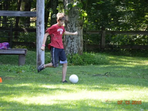 a boy kicking a football ball