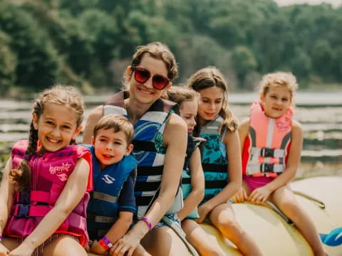 a group of kids in life jackets on a boat