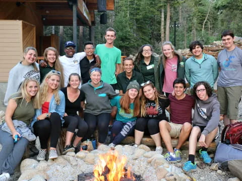 a group of people posing for a photo next to a fire